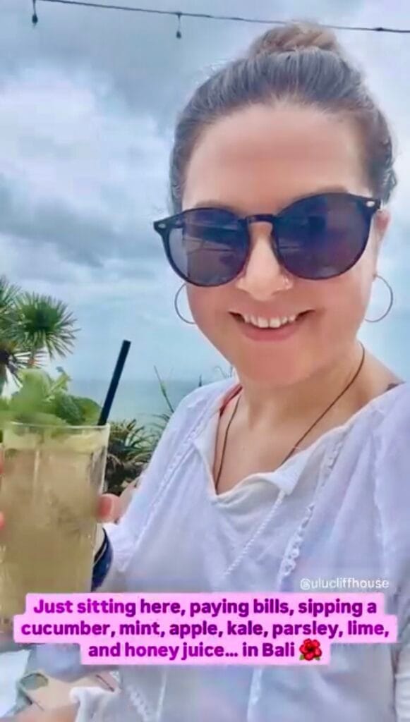 Marybeth sitting in Bali, paying bills while sipping a tropical juice and building her business.